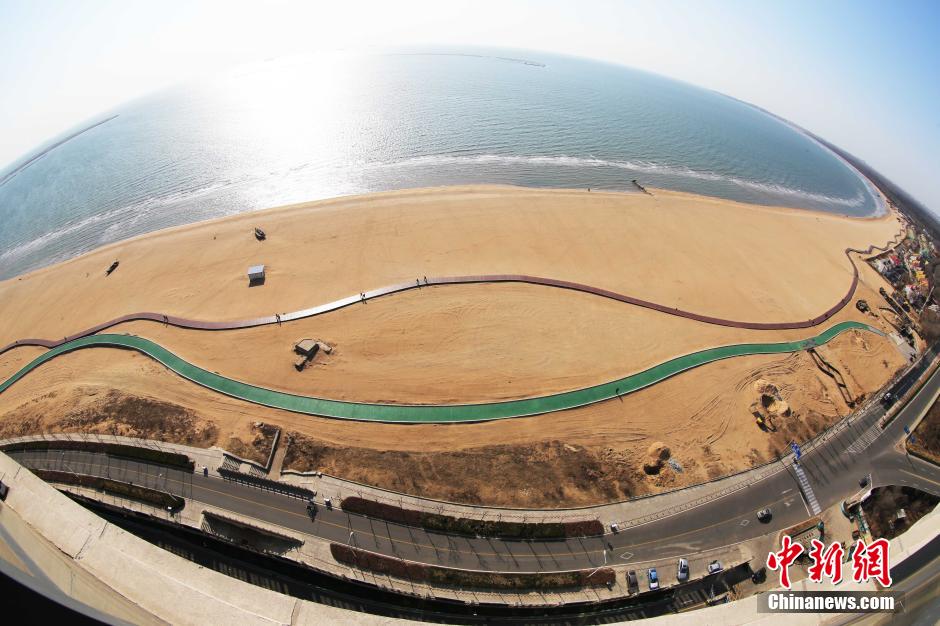 3月13日，秦皇島萬米臨海沙灘木棧道。據(jù)了解，該木棧道全長約4200米，與北戴河區(qū)原有的7500米木棧道對接后全線總長度1.17萬米，整個木棧道東起秦皇島體育基地游船碼頭，西至北戴河濕地公園，呈波浪形蜿蜒10.4公里海岸線。 中新社發(fā) 曹建雄 攝 CNSPHOTO